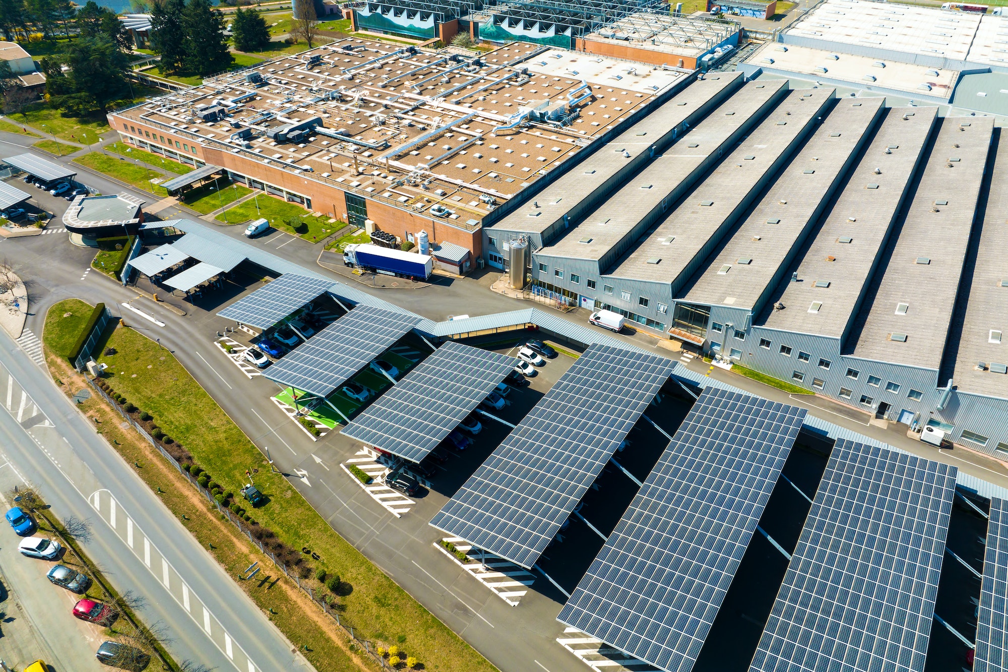 Aerial view of solar panels installed as shade roof over parking lot with parked cars