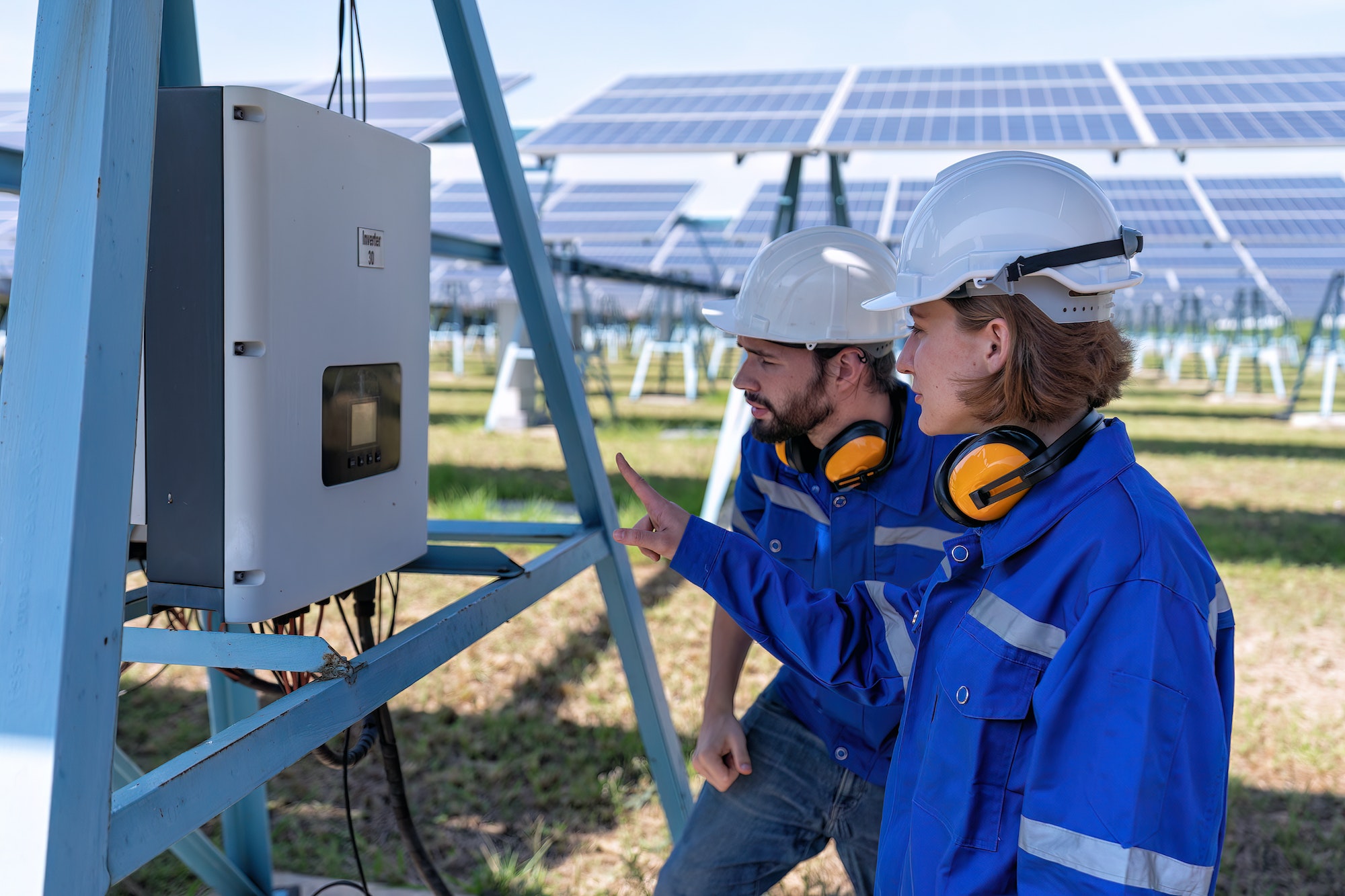 pracownicy patrzą na falownik solarny