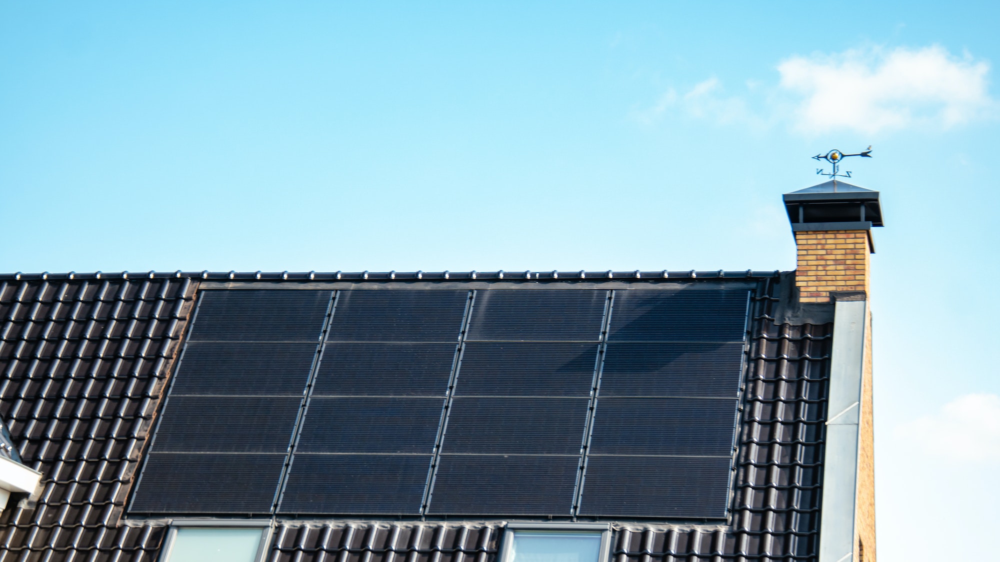Newly build houses with solar panels attached on the roof against a sunny sky
